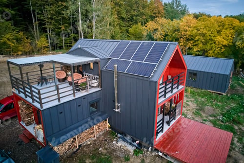 Preview: New modern house cottage with solar photovoltaic panel system on roof. Aerial view.