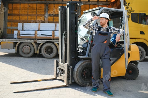 Preview: Portrait of professional forklift driver in factory's warehouse