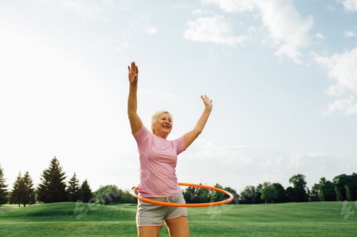 Preview: elderly woman does the exercise with hoop, laughing and enjoy the rest at park. Hoop Workout