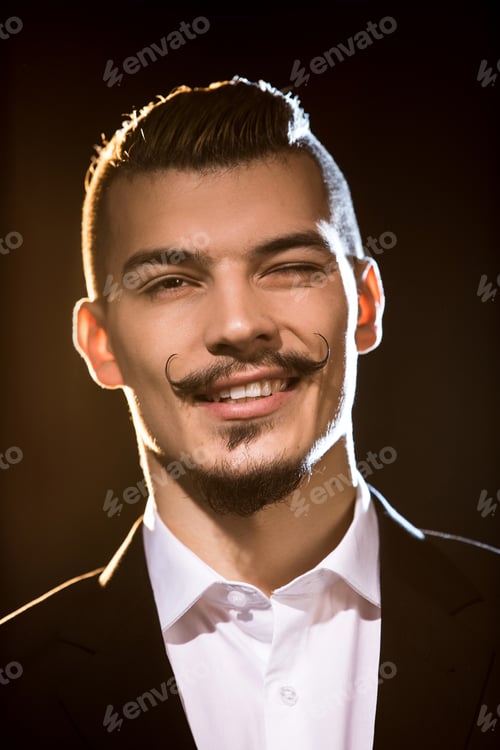 Preview: Close-up portrait of handsome bearded man in suit smiling and winking