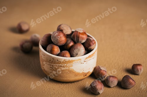 Preview: Pile of hazelnuts filbert in a bowl on a brown background.