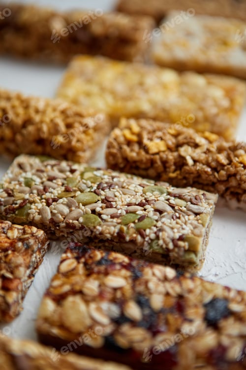 Preview: Close up on healthy granola fit bars arragement. Placed on white table