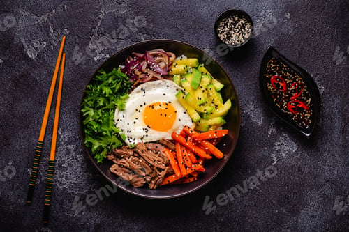 Preview: Traditional Korean dish Bibimbap: rice with vegetables beef and egg.