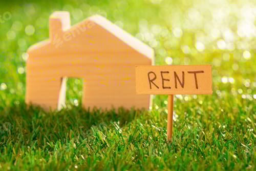 Preview: Wooden toy house with rent sign on grass