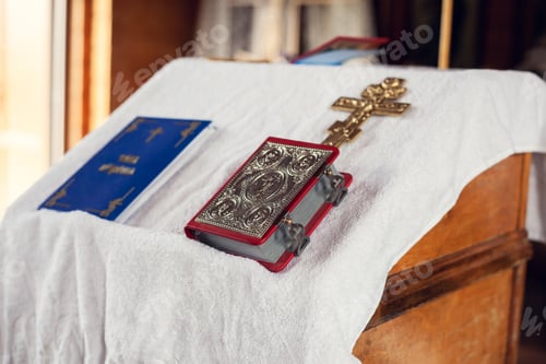 Preview: The sacrament of baptism in the Orthodox Church. Prayer books and a crucifix on the table