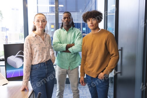 Preview: Diverse team standing in office, looking serious