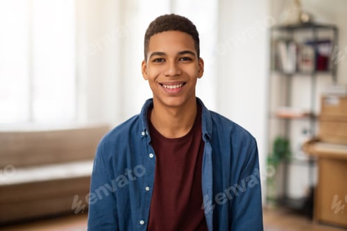 Preview: Smiling young man posing for camera in casual attire