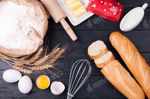 Preview: Baking background. Flour in paper bag, eggs, butter, milk, rolling pin and whisk on dark