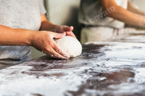 Preview: Baker preparing bread. Close up of hands kneading dough.