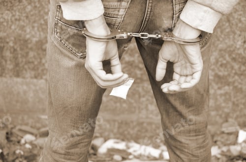 Preview: Arrested drug dealer in police handcuffs with small heroin drug