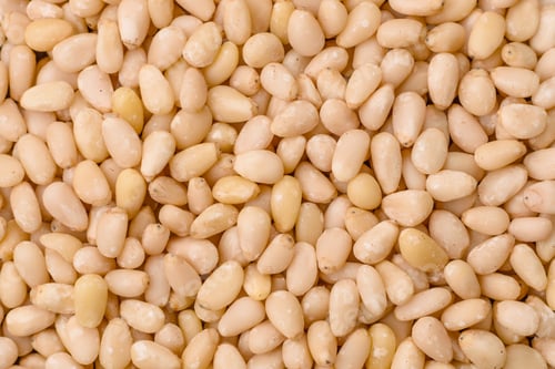 Preview: Peeled pine nuts in a bowl on a dark concrete background