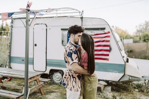 Preview: Beautiful Spanish couple kissing on background of the US flag - US Independence day