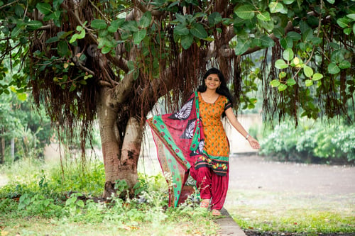 Preview: Happy Indian woman near banyan tree