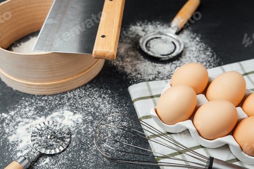 Preview: Cooking preparation with fresh eggs and baking tools on a kitchen countertop