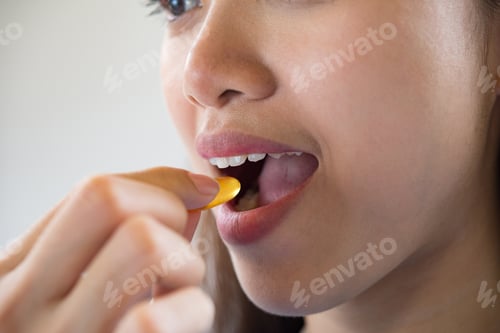 Preview: Young woman taking medicine pill after doctor order