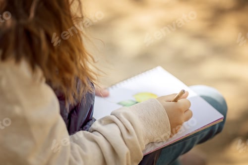 Preview: Little girl paints in open air in spring blooming fairytale park. Children's drawings. Creative kid.