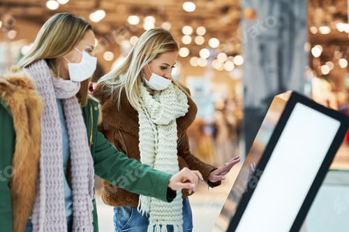Preview: Portrait of two friends shopping together wearing a mask, coronavirus concept