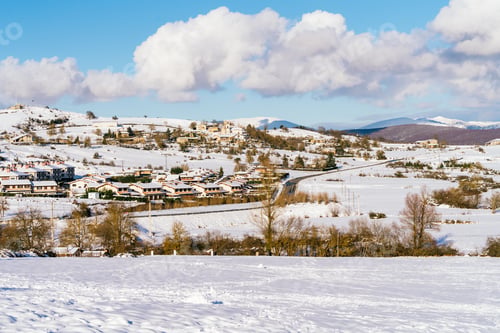 Preview: beautiful landscape where you can see a snowy village with a very blue sky and some white clouds
