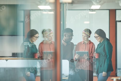 Preview: Young Ethnic Team Behind Glass in Modern Office