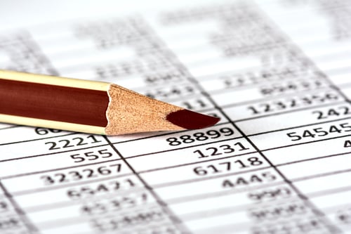 Preview: Closeup of a paper with calculations next to a red pencil