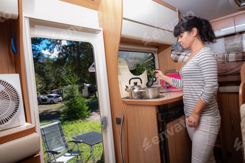 Preview: Woman cooking in camper, motorhome interior RV