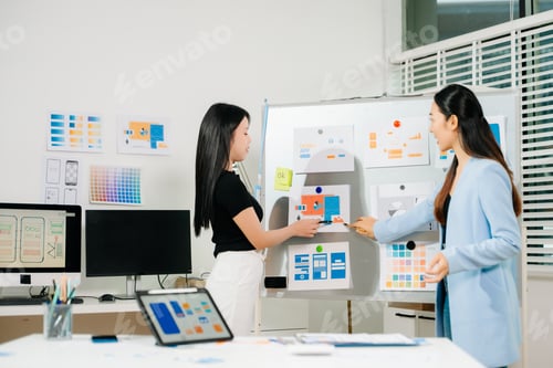 Preview: UX UI designers presenting mobile app wireframes and color palettes during a creative startup