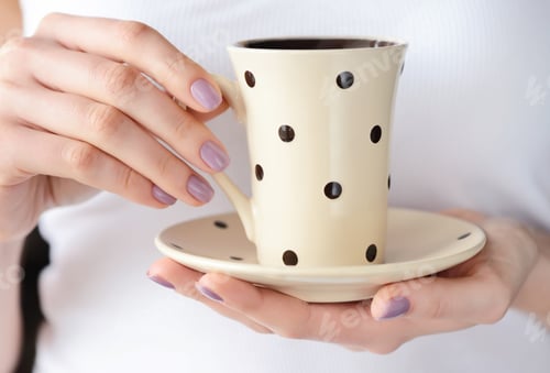 Preview: Hands of a young woman holding a cup