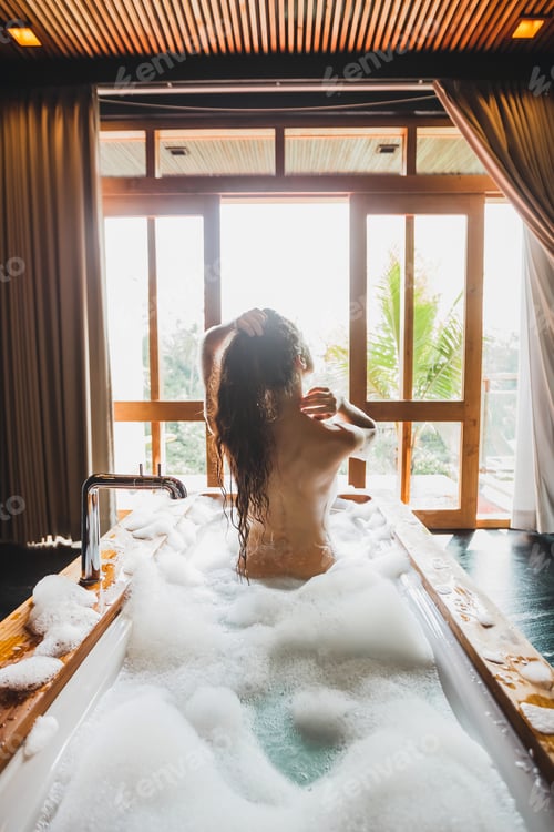 Preview: Slim beautiful girl enjoying in bath full of foam. Enjoying in hotel spa room