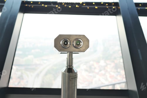 Preview: Coin-operated binoculars looking out over city ,