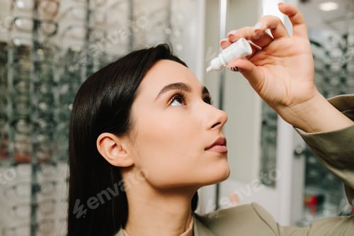 Preview: Eye clinic treats irritation. Doctor administers eye drops to woman patient