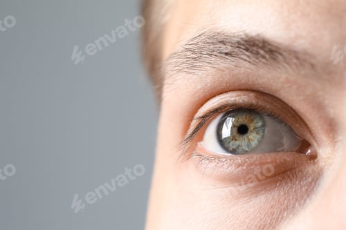 Preview: Perfect vision. Man with beautiful eyes on grey background, closeup. Space for text