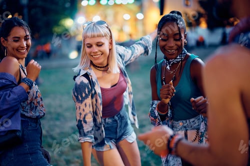 Preview: Happy festival goers dancing at music concert during summer.