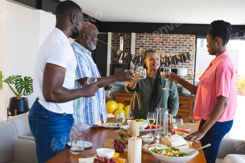 Preview: Family celebrating retirement with toasts and smiles around dining table at home