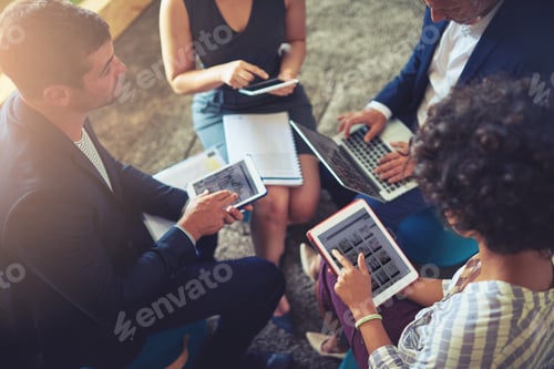 Preview: High angle shot of a group of businesspeople using their digital tablets