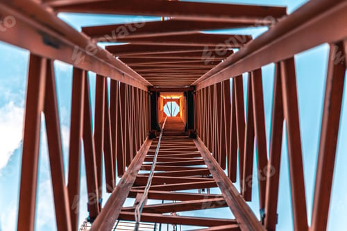 Preview: View of looking up inside a construction crane under the blue sky