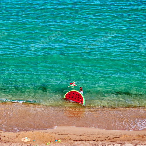 Preview: Boy and his mother on beach with inflatable float