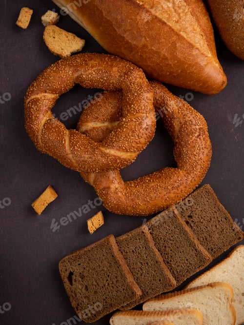 Preview: side view of breads as bagel, baguette, sliced rye and white breads on maroon background