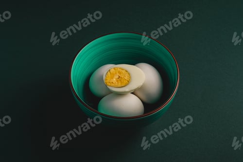 Preview: Boiled egg with yellow yolk with white eggs in green bowl