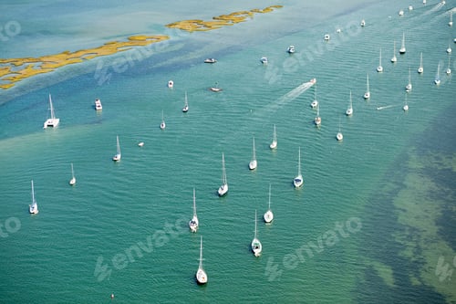 Preview: A serene aerial view of sailboats on a tranquil sea.