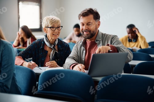Preview: Adult students cooperating while using laptop and studying together in the classroom