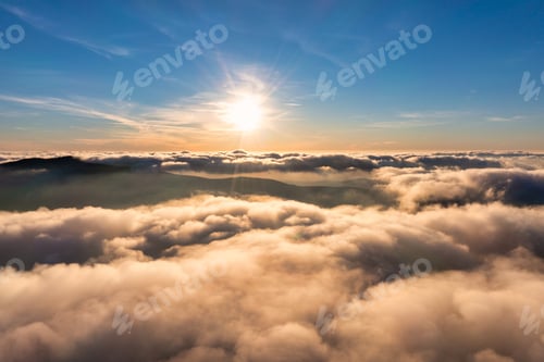 Preview: Golden Sunrise Over Mountain Peaks Covered in Clouds