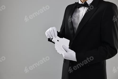 Preview: Illusionist taking one playing card from deck on grey background, closeup. Space for text