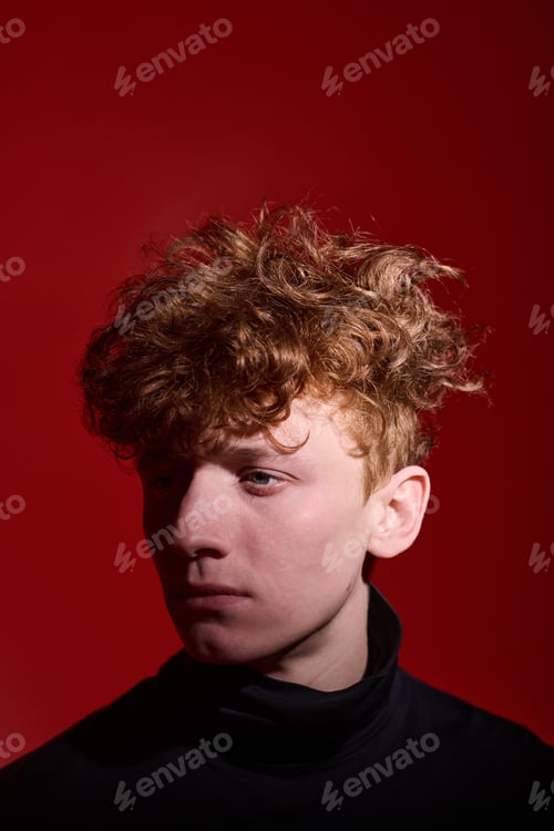 Preview: Capturing Thoughtful Expression of Young Man Against Red Background