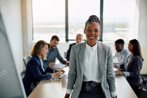Preview: Happy black businesswoman during a meeting in the office looking at camera.