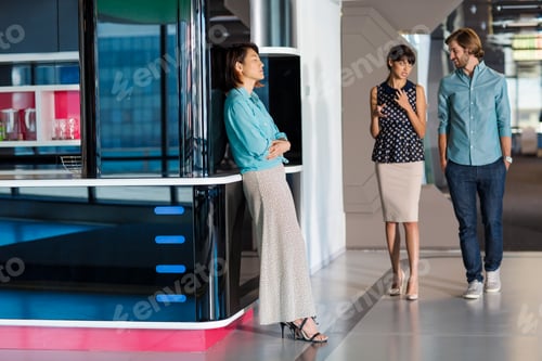 Preview: Exhausted businesswoman leaning on wall in busy office corridor