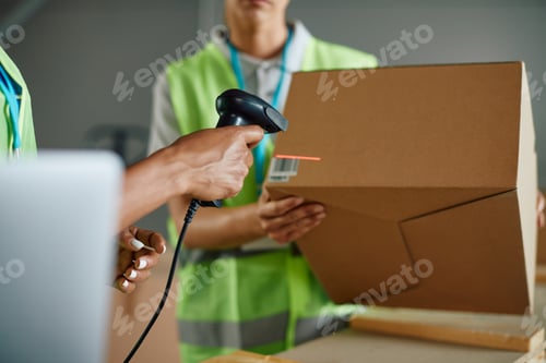 Preview: Close up of workers preparing packages for shipment and scanning labels at distribution warehouse.