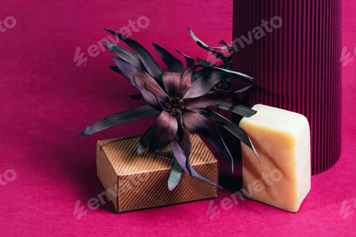 Preview: Piece of soap with ruffle carton box and dry flower on purple paper.