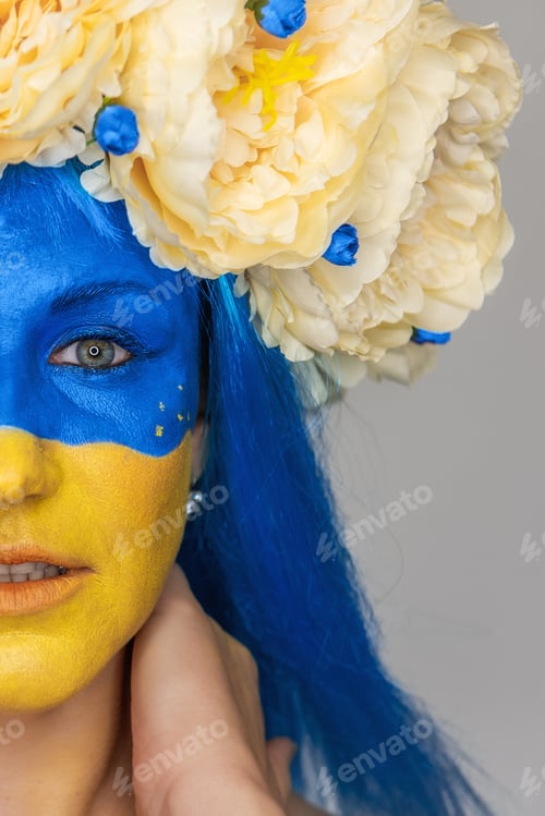 Preview: Creative close-up portrait of young woman with yellow blue face art. Concept for Flag Day in Ukraine