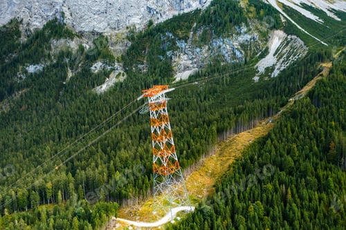 Preview: Power line pylon high in the mountains surrounded by trees