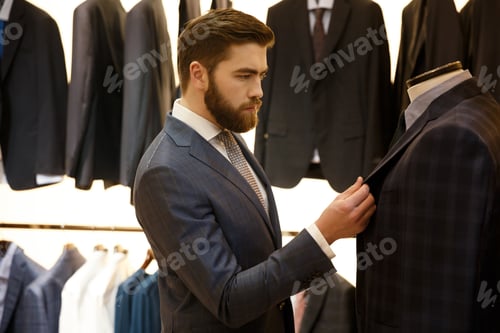 Preview: Side view of man choosing a jacket in shop